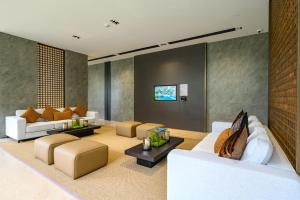 a living room with white couches and a tv at Beachfront 1BDR Condo (PE24) in Na Jomtien