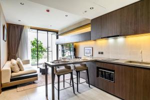 a kitchen with a counter and a table and chairs at Beachfront 1BDR Condo (PE24) in Na Jomtien