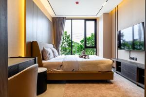 a bedroom with a bed and a large window at Beachfront 1BDR Condo (PE24) in Na Jomtien +88 photos