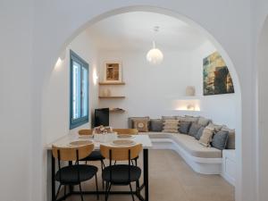 a living room with a couch and a table and chairs at Kamara House - 200m from Naoussa Port in Naousa