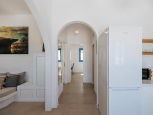 a hallway with an archway in a white apartment at Kamara House - 200m from Naoussa Port in Naousa +19 photos