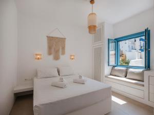 a white room with a bed and a window at Kamara House - 200m from Naoussa Port in Naousa