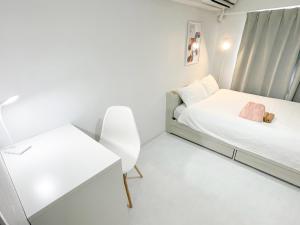 a small white room with a bed and a desk at Kameari 1110 - 11F Newly Renovated High Floor City View 2min to Mall 5min to Station Disney Access in Tokyo