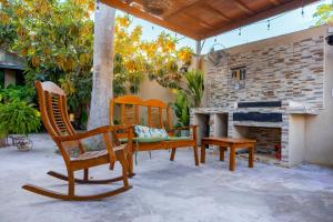 a patio with chairs and a table and a fireplace at Departamento 1 Hab con Alberca, Gym y Terraza in Mérida