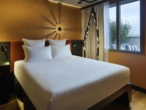 a large white bed in a room with a window at Tribe Paris Saint Ouen in Saint-Ouen
