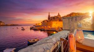 a view of a harbor at sunset with a city at Valletta Waterfront Villa with Pool and Jacuzzi in Valletta