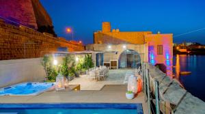 a house with a swimming pool next to the water at Valletta Waterfront Villa with Pool and Jacuzzi in Valletta +57 photos