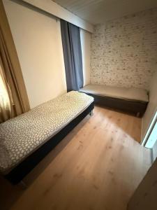 a small room with a bed and a window at Kolmio Kaurialassa in Hämeenlinna