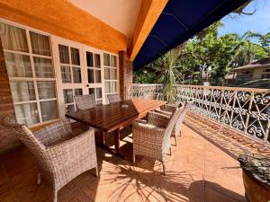 ein Holztisch und Stühle auf einer Terrasse in der Unterkunft Coco Grande Hotel in Dumaguete