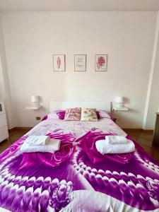 a bedroom with a bed with a purple blanket at La Dolce Vita in Bracciano