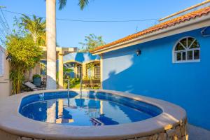 a swimming pool in front of a blue house at Departamento 1 Hab con Alberca, Gym y Terraza in Mérida