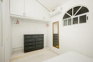a bedroom with a black dresser and a window at Departamento 1 Hab con Alberca, Gym y Terraza in Mérida +43 photos