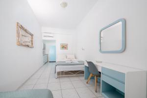 a room with a bed and a desk and a mirror at ALMA THERA Boutique Hotel in Perissa +68 photos