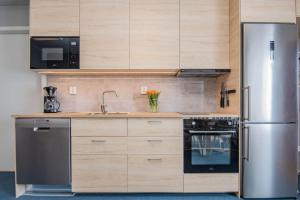a kitchen with a stainless steel refrigerator and a sink at Hemavan Mountain Lodge Jofjället in Hemavan