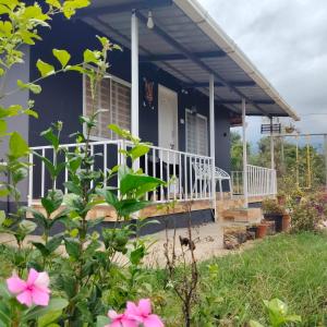 a blue house with a porch with pink flowers at Airin's Villa in Agali
