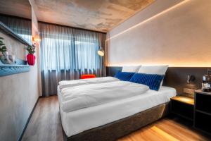 a bedroom with a large white bed and blue pillows at Savoy Hotel in Frankfurt