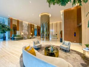 a lobby of a hotel with a couch and chairs at Vasa Suite Surabaya in Surabaya +13 photos
