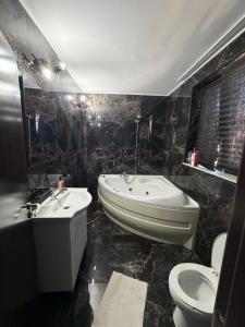 a bathroom with a tub and a toilet and a sink at Hypnotic Boutique Pitesti in Piteşti +41 photos