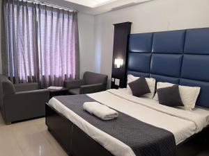 a bedroom with a large bed with a blue headboard at Hotel Chandigarh Grand in Chandīgarh