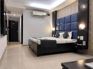 a bedroom with a large bed with a blue wall at Hotel Chandigarh Grand in Chandīgarh