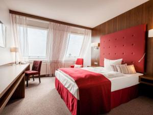 a hotel room with a large bed with a red headboard at Fora Hotel Hannover by Mercure in Hannover +123 photos