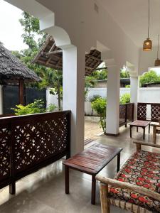 a porch with a bench and a table at vayana nungwi in Nungwi