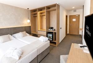 a hotel room with two beds and a television at Spa Hotel Devin in Mariánské Lázně