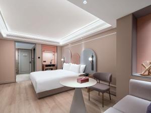 a hotel room with a bed and a table at Mercure Chengdu Wuhou Temple in Chengdu