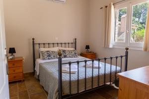 a bedroom with a bed and a window at Charmante petite maison à Corfou in Pelekas