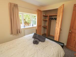 a bedroom with a bed with a hat on it at Ryecross Farm Cottage in Melbury Abbas