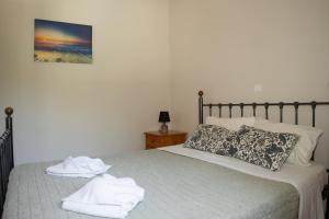 a bedroom with a bed with towels on it at Charmante petite maison à Corfou in Pelekas +32 photos