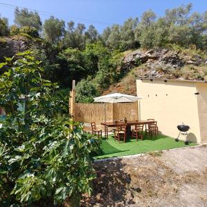 a table with an umbrella and chairs on a lawn at Nostra Torre in Filettole