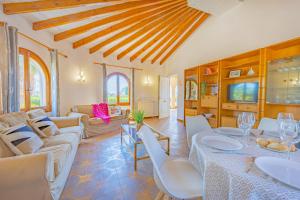 a living room with a table and chairs and a couch at Villa Ortembach- PlusHolidays in Ifach