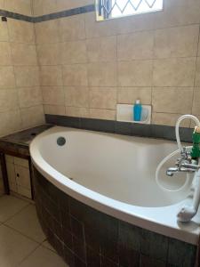 a bath tub in a bathroom with a sink at Amboseli 2 in Mombasa +6 photos