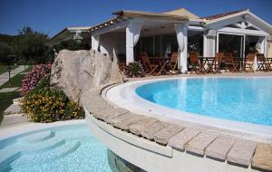a swimming pool in front of a house at Cento Ulivi B&B in Golfo Aranci