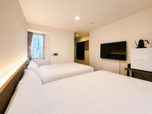 a hotel room with two beds and a flat screen tv at ホテル翔 Sapporo PARKSIDE HOTEL in Sapporo +7 photos