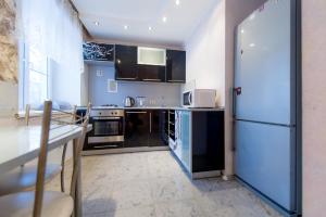 車里雅賓斯克的住宿－Five Stars Cozy Studio，厨房配有黑色橱柜和白色冰箱。