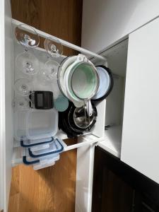 an open refrigerator filled with dishes and utensils at Cozy studio in Cancale in Cancale