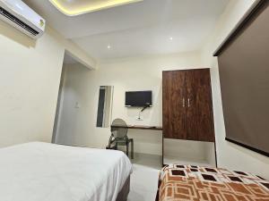 a bedroom with a bed and a desk and a tv at AVON Homes in Jodhpur