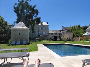 a person laying on a bench next to a swimming pool at La ROCHE D'ANJOU in Saint-Mathurin