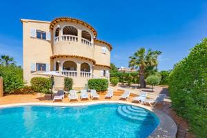 a villa with a swimming pool in front of a house at Villa Ortembach- PlusHolidays in Ifach