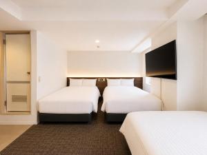 a hotel room with two beds and a flat screen tv at ホテル翔 Sapporo PARKSIDE HOTEL in Sapporo
