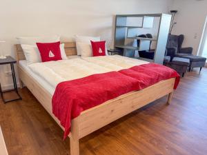 a large bed with a red blanket on top of it at Boardinghouse in Büsum