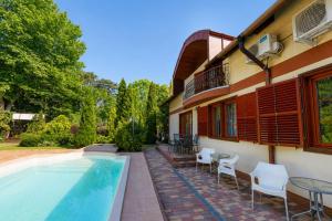 a house with a swimming pool and tables and chairs at Marina Panzio in Siófok