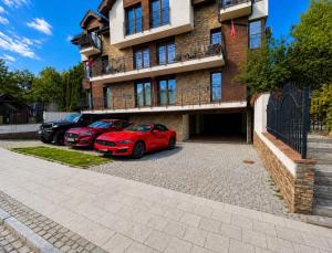 two cars parked in a parking lot in front of a building at Rezydencja Wind Rose Luxury ApartHotel Gdańsk - Prywatne SPA in Gdańsk