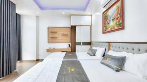 a bedroom with two beds and a painting on the wall at Phượng Sơn Hotell in Sầm Sơn
