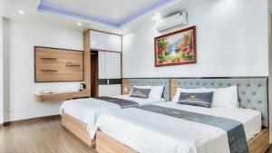 two beds in a hotel room with two bedsvisor at Phượng Sơn Hotell in Sầm Sơn