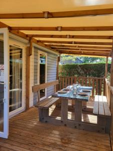 a wooden deck with a table and a bench at Ocean Lodge Messanges in Messanges