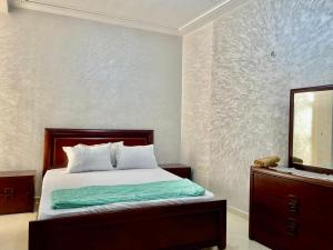 a bedroom with a bed with a dresser and a mirror at luxury apartment in fez in Fez