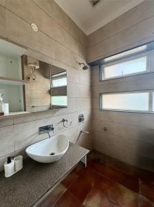 a bathroom with a sink and a mirror at Red Brick House in Panchkula